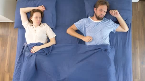 Концепция проблем в паре. сексуальные проблемы. пара, недовольные мужчина и женщина лежат в постели. вид сверху — стоковое видео