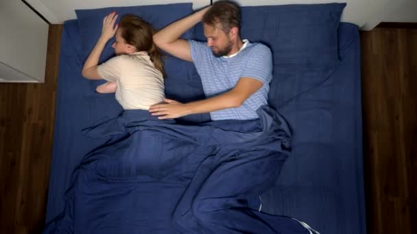 Concepto de problemas en un par. problemas sexuales. pareja, hombre y mujer disgustados están acostados en la cama. vista superior — Vídeos de Stock