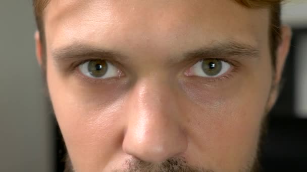 Primer plano, hombre guapo de ojos verdes perplejo mira a la cámara — Vídeos de Stock