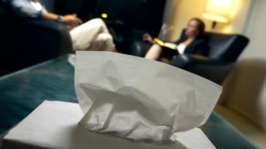 psikolojik danışmanlık. kağıt peçeteler, psikologlar ofiste tabloda odaklanmak. Bir kadın bir defter ile başarılı bir adam ile iletişim kurar. akşam bir deri ofisinde oturup