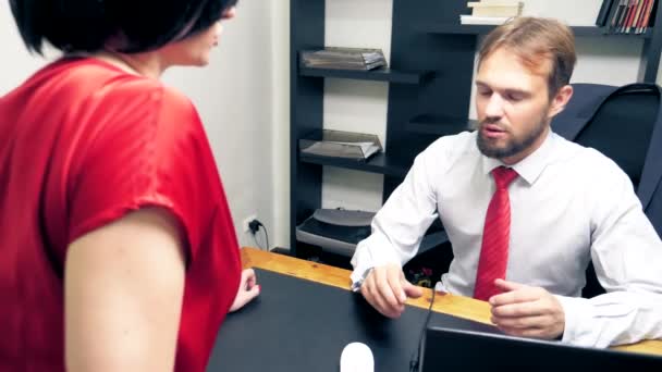 Penggoda kantor. Pria close-up berbicara dengan brunette dalam pakaian merah. menggoda koleganya . — Stok Video