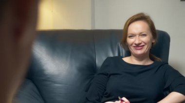 genel kavram-in müzakere, psikolojik danışmanlık. Bir kadın bir defter ile başarılı bir adam ile iletişim kurar. akşam bir deri sandalye ofisinde oturuyor.