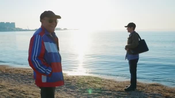 Senior couple walking at the beach on the northern sea. Spending time together. — Stock Video