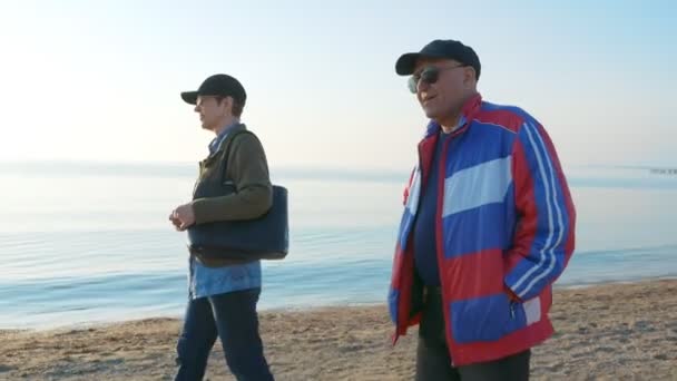 Casal sênior caminhando na praia no mar do norte. Passar tempo juntos . — Vídeo de Stock