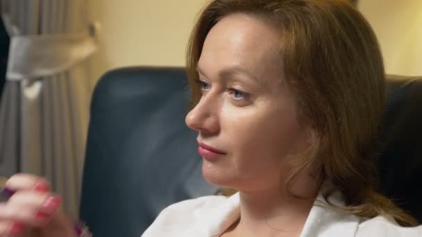 Portré, üzleti nő beszélgetés közben mosolyog, ül este az irodában egy fekete bőr szék — Stock videók
