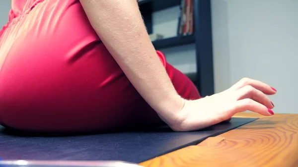 Female hands with long red nails are knocking on the table on. A woman in a red jumpsuit sits on a table and waits. — Stock Photo, Image