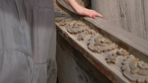 Close-up. mulheres desliza de mão em um corrimão esculpido em madeira em um templo budista de madeira — Fotografia de Stock