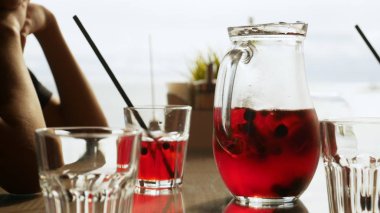 Bir kafede bir masada bir sürahi çilek ile ferahlatıcı kırmızı limonata