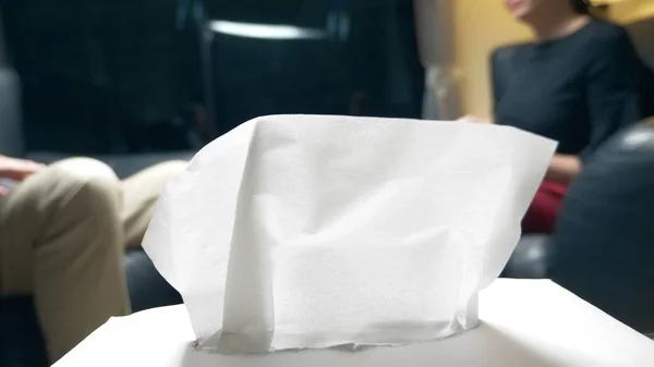 Counselling psychologique. se concentrer sur les serviettes en papier, sur la table dans le bureau des psychologues. Une femme avec un cahier communique avec un homme qui réussit. le soir, je m'assois au bureau dans un cuir — Photo