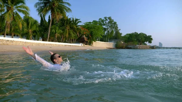 Mulher de negócios feliz em terno e óculos escuros está salpicando no mar em resorts de luxo. O conceito de umas férias bem esperadas, freelancer . — Fotografia de Stock