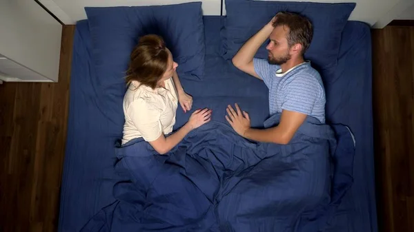 Het concept van een probleem in een paar. seksuele problemen. echtpaar in bed. de vrouw geeft uiting aan haar ongenoegen aan de man. van bovenaf bekijken. — Stockfoto