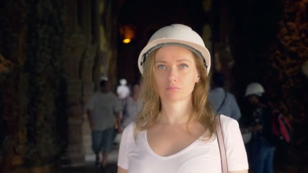 Woman tourist in helmet explores wooden buddhist temple inside — ストック動画