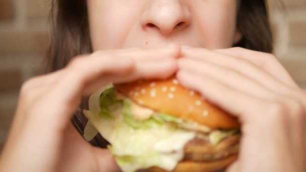 Nära. Teen flicka äter hamburgare — Stockvideo