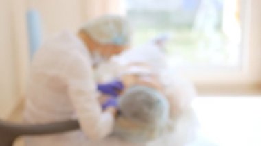 Bulanık arka plan. Kozmetolojist enjeksiyonlar yapar, bir kadının yüz ve boyun cilt kırışıklıkları sıkma ve yumuşatma için anti-aging prosedürleri.
