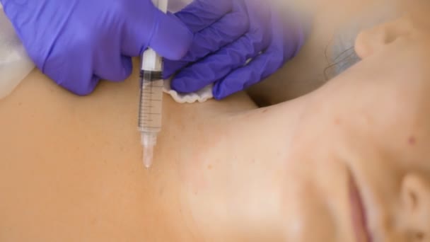 El cosmetólogo realiza inyecciones, procedimientos antienvejecimiento para apretar y alisar las arrugas en la piel de la cara y el cuello de una mujer . — Vídeos de Stock