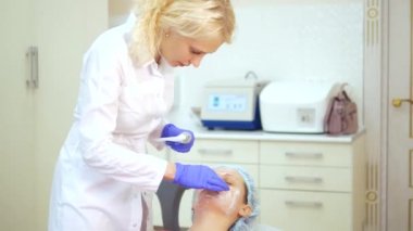 Güzellik uzmanı kavramı. Güzellik kız yüzüne krem koyar