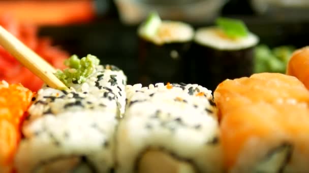 Close-up. alguém toma sushi com pauzinhos, rolos . — Vídeo de Stock