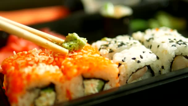 Close-up. někdo si vezme sushi s hůlky, rolky. — Stock video