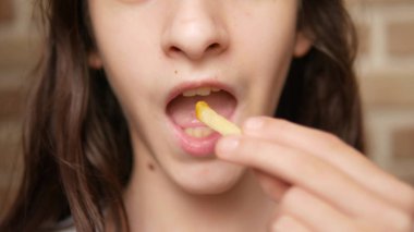 Close. çocuk ağzı. genç patates kızartması yiyor.