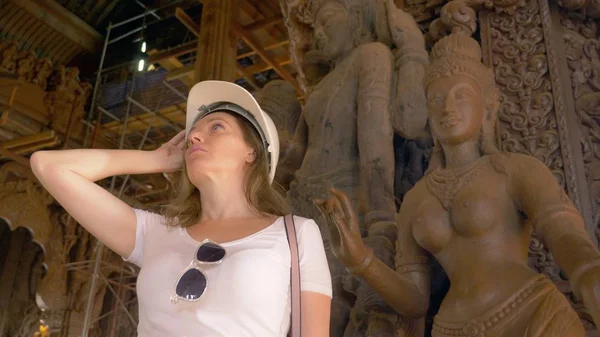 Mulher turista no capacete explora templo budista de madeira dentro — Fotografia de Stock