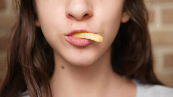 Nahaufnahme. Kindermund. Teenager isst Pommes. — Stockfoto