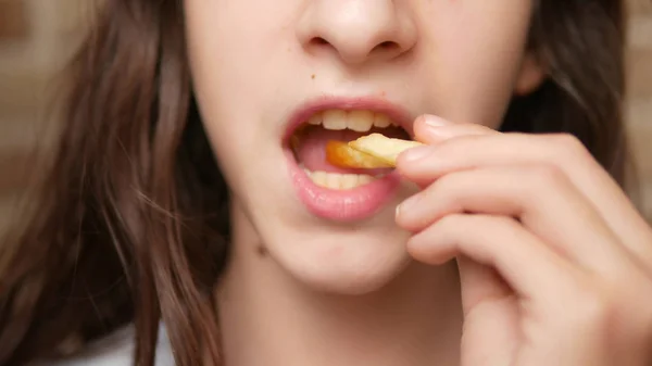 Primer plano. boca de niño. adolescente come papas fritas . — Foto de Stock