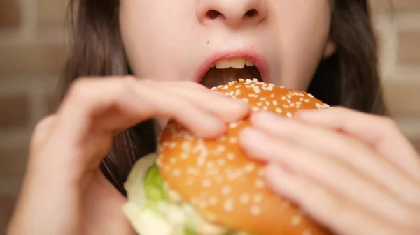 Cerca. boca de niño. chica comiendo una hamburguesa — Foto de Stock