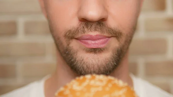 Boca de cerca. hombre muerde un pedazo de hamburguesa — Foto de Stock