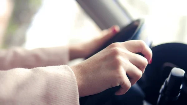 Женские руки в розовом пальто на руле автомобиля. женщина за рулем весной или осенью — стоковое фото