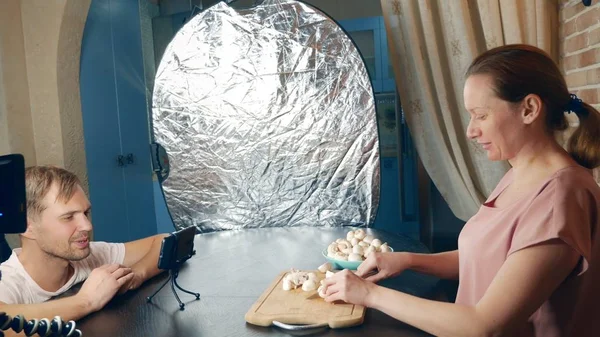 Memasak kursus online. memasak dan kuliner konsep pelatihan kelas. seorang narablog perempuan menyiapkan jamur-jamur di dapur dan membuat video tentang dirinya sendiri dengan menggunakan ponsel tripod . — Stok Foto