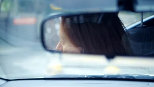 Riflesso di un volto femminile nello specchio retrovisore, una donna prepara uno specchio retrovisore prima di guidare — Video Stock