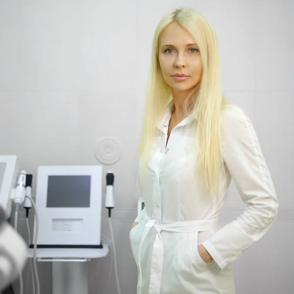 Dokter wanita muda yang menarik di kantor dengan latar belakang peralatan medis . — Stok Foto