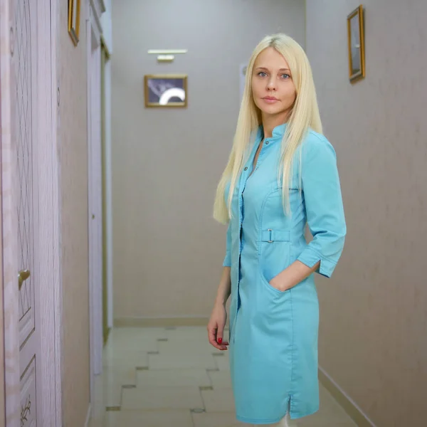 Retrato de uma mulher loira confiante médico em uniforme médico azul — Fotografia de Stock