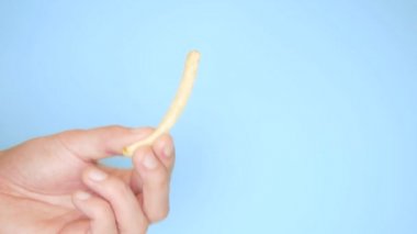 mavi arka plan üzerinde patates kızartması ile erkek el
