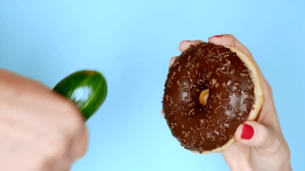 Az egészséges táplálkozás és táplálkozás fogalma. csokoládé fánk ellen, zöld uborka. Fun gyorsétterem-projekt — Stock videók