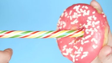 mavi arka plan üzerinde pembe donut ve lolipop. yemek ruh hali. Eğlenceli fast food projesi