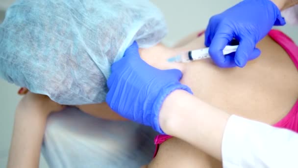 Neurologe spritzt dem Patienten eine Spritze in den Rücken entlang der Wirbelsäule — Stockvideo