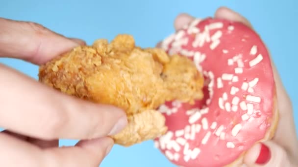 Az egészséges táplálkozás és táplálkozás fogalma. sült csirke lábát egy rózsaszín fánk. Fun gyorsétterem-projekt — Stock videók