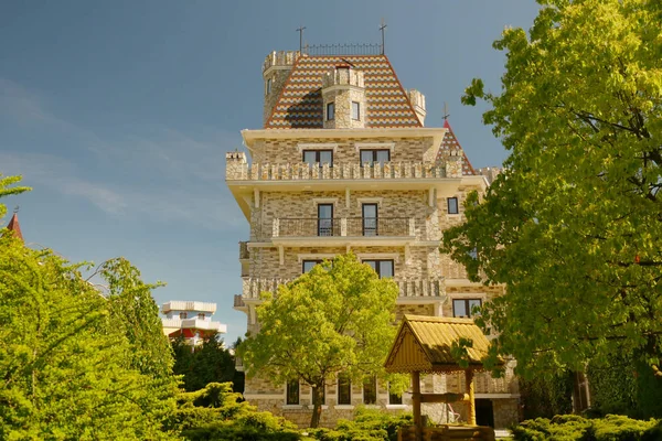 Hôtel de luxe moderne de style victorien avec de beaux arbres bien entretenus contre le ciel bleu par temps clair et ensoleillé — Photo