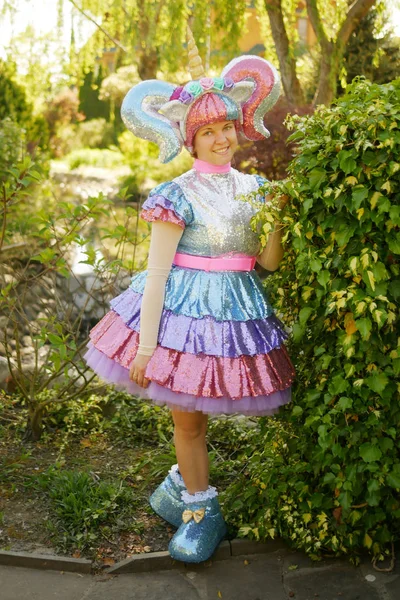 Linda chica animador en un traje de unicornio en el parque en la hierba verde — Foto de Stock