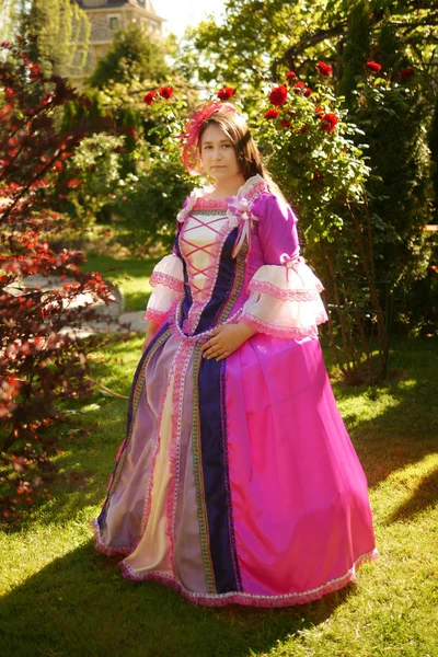 Animador menina vestida como uma princesa medieval no fundo do castelo em um belo parque — Fotografia de Stock