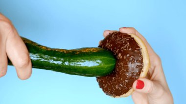 Sağlıklı bir diyet ve diyet kavramı. yeşil salatalık karşı çikolatalı çörek. Eğlenceli fast food projesi