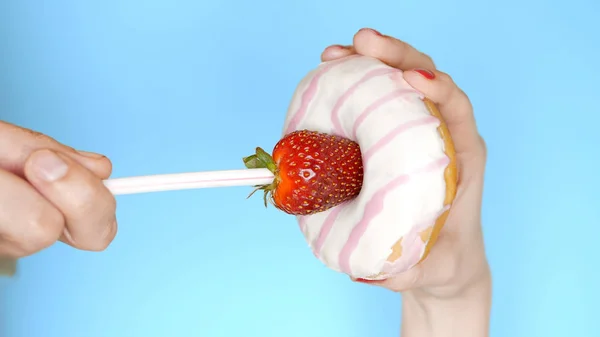 The concept of a healthy diet and diet. Strawberries and white pink donut. Fun fast food project — Stock Photo, Image