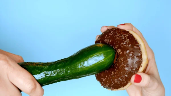 Концепция здорового питания и диеты. шоколадный пончик против зеленого огурца. Веселый проект быстрого питания — стоковое фото