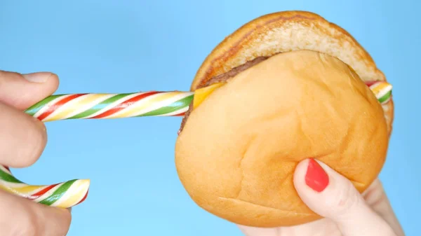 Концепция здорового питания и диеты. полосатые длинные конфеты и гамбургерный киоск. Веселый проект быстрого питания — стоковое фото
