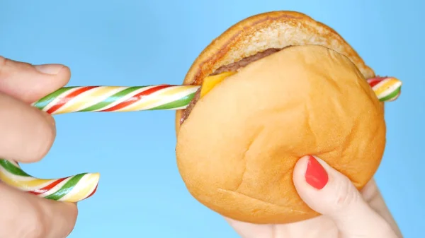 Концепция здорового питания и диеты. полосатые длинные конфеты и гамбургерный киоск. Веселый проект быстрого питания — стоковое фото