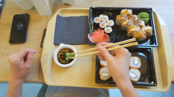 箸で寿司を食べてカフェで、若い女性。4 k、クローズ アップ。上からの眺め — ストック動画
