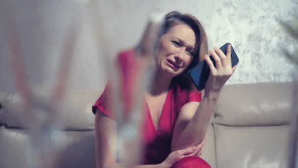 Plačící žena čeká na někoho doma u stolu na romantickém rande pro dva. zkontroluje telefonní — Stock video