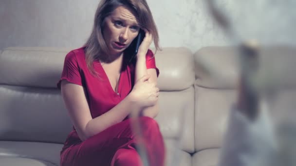 Ağlayan bir kadın iki romantik bir tarih için ayarlanmış bir masada evde birini bekliyor. telefonu kontrol eder — Stok video
