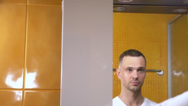 Portrét hezkého muže s maskou pod oční víčkem, v koupelně. Metrosexuální koncepce, péče o obličej — Stock video